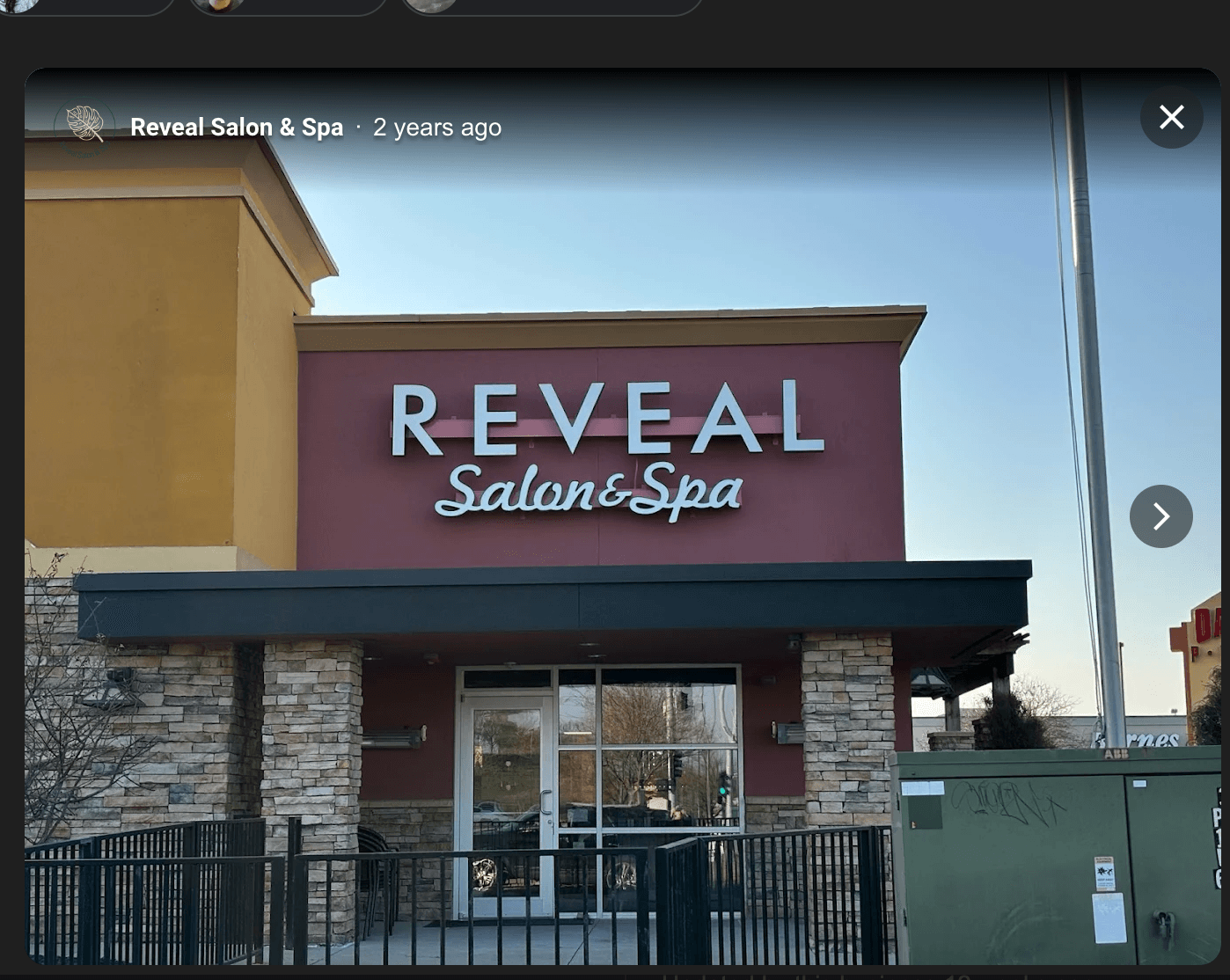 Reveal Salon & Spa storefront with REVEAL signage, burgundy facade and stone columns