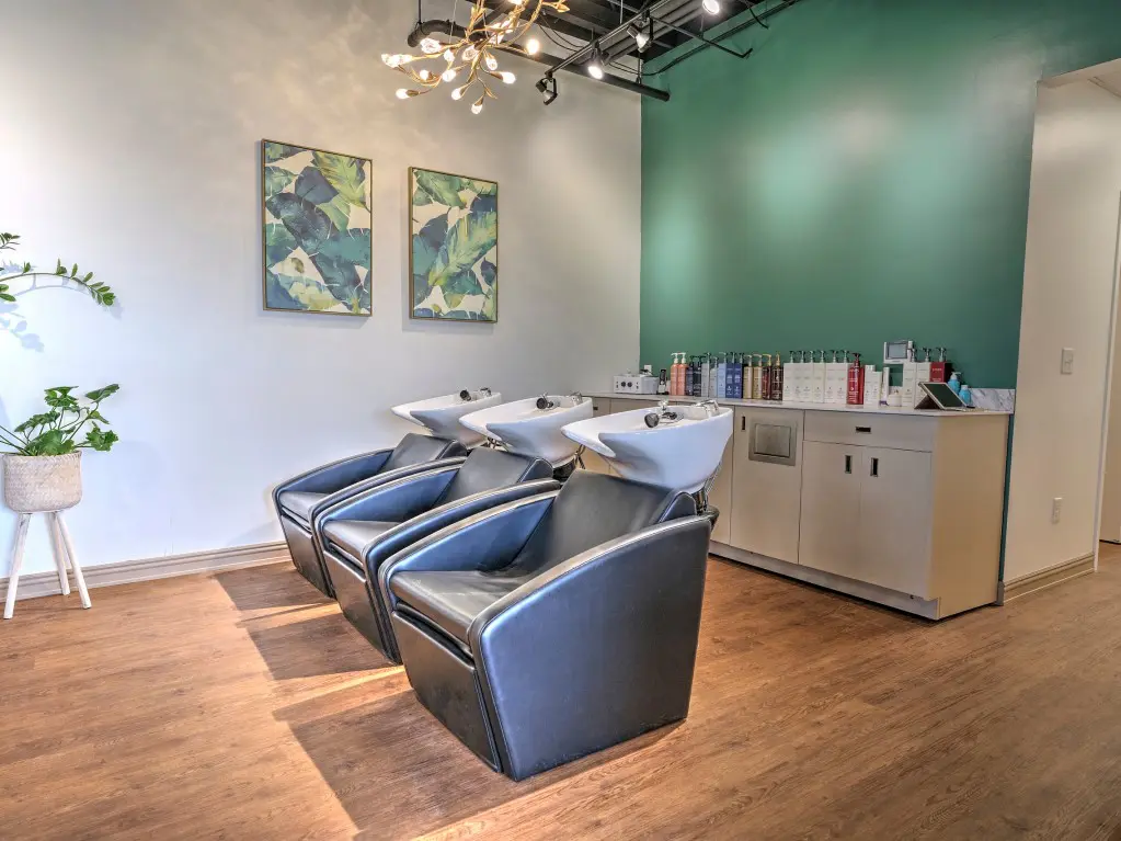 A room with three chairs and two sinks.